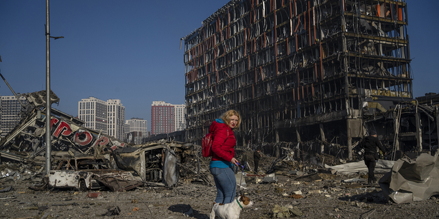 Irina Zubchenko führt ihren Hund Max inmitten der Verwüstung aus, die am Montag durch die Bombardierung eines Einkaufszentrums in Kiew, Ukraine, verursacht wurde.
