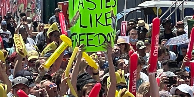 Eine Person, die ein Schild mit der Aufschrift hält "Schmeckt nach Freiheit" Während Nathans berühmtem Hot-Dog-Wettbewerb in Coney Island am 4. Juli 2022.