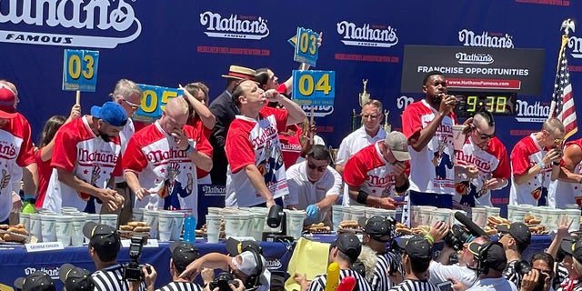 Die Teilnehmer konkurrieren darum, wer die meisten Hot Dogs während des berühmten Nathan's Hot Dog Eating Contest am 4. Juli 2022 auf Coney Island essen kann.