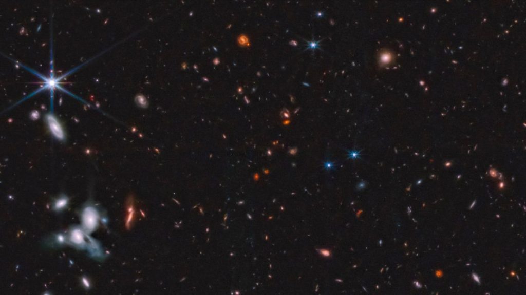 A section of the Epoch 1 mosaic, with a pair of interacting spiral galaxies visible in the bottom left corner, also with a white spot indicating possibly the first supernova captured by JWST.