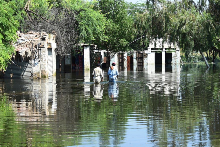 Die Bewohner waten nach heftigen Monsunregen in der Nähe ihrer Häuser im Hochwasser.